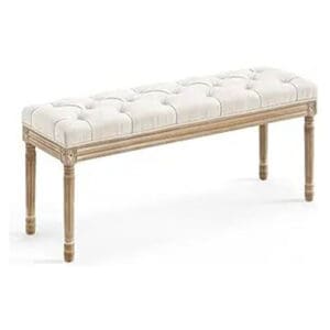 A bench with white tufted seat and wooden legs.